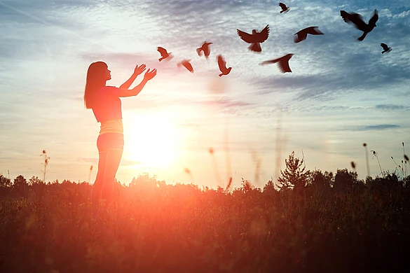 silueta mujer con palomas al viento